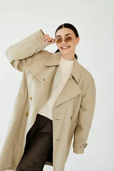 Une jeune femme présente un look d'automne chic avec confiance dans un studio minimaliste, respirant chaleur et style. — Photo de stock