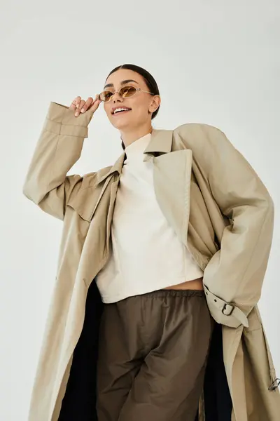 A young woman models a chic autumn outfit, exuding confidence and style in a bright studio setting. — Stock Photo