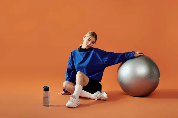 A captivating sportswoman expresses her emotions while engaging with a stability ball. — Stock Photo