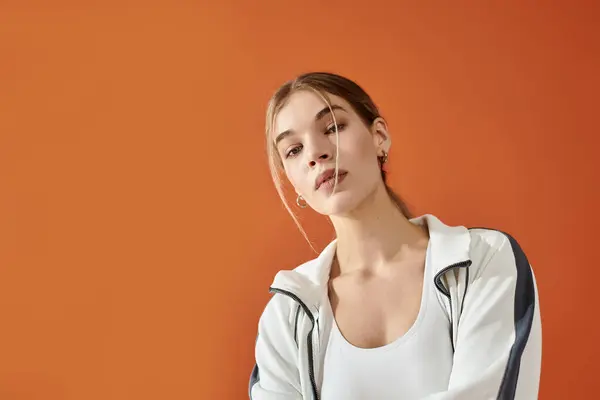 A talented athlete shows her emotional side against a striking orange background, capturing focus. — Stock Photo