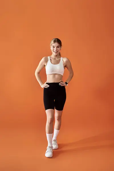 A beautiful athlete expresses her emotions while posing gracefully against a bright backdrop. — Stock Photo
