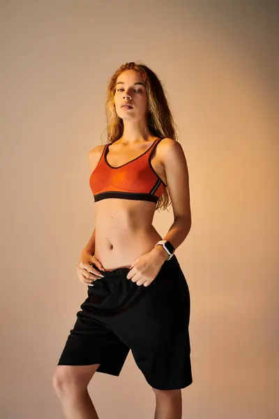 Una donna atletica irradia fiducia e determinazione mentre posa appassionatamente in abbigliamento sportivo. — Foto stock