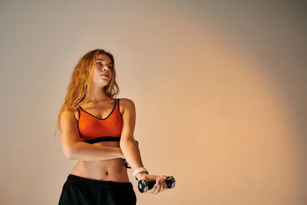 A passionate sportswoman showcases her strength while lifting weights, exuding emotion and focus. — Stock Photo