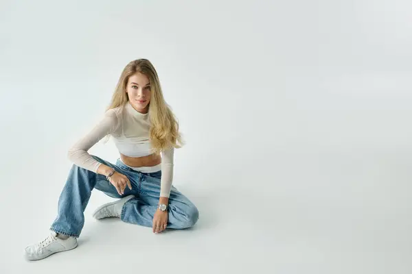 A fashionable young woman sits comfortably on the floor, showcasing her style and confidence. — Stock Photo