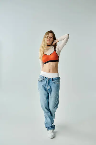 A stylish young woman showcases her fashion sense with a confident pose in a clean studio. — Stock Photo