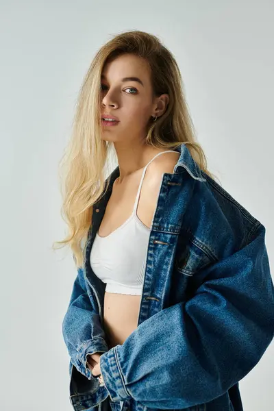 A young woman displays confidence in a denim jacket and simple top. — Stock Photo