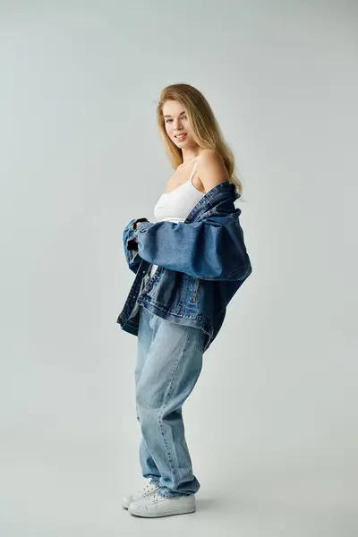 A stylish young woman wears a denim jacket over a simple top, creating a relaxed vibe. — Stock Photo