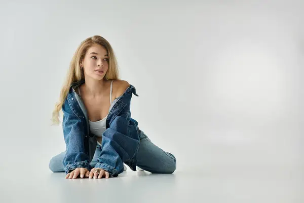 A young woman with flowing hair expresses confidence while sitting in a stylish pose. — Stock Photo
