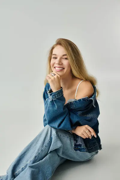 A young woman radiates happiness as she poses confidently in her casual denim outfit. — Stock Photo
