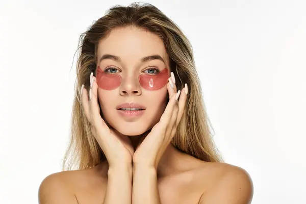 Diese junge Frau hält ihr Gesicht sanft, während sie erfrischende Hautpflaster präsentiert. — Stockfoto