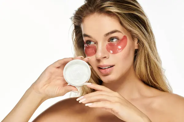 A young beautiful woman engages in her skincare routine, enhancing her natural glow with patches. — Stock Photo