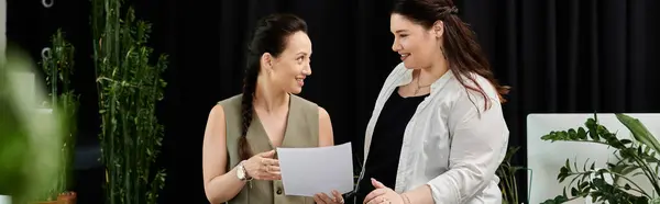 Two stylish professionals engage in a spirited discussion while reviewing important documents. — Stock Photo