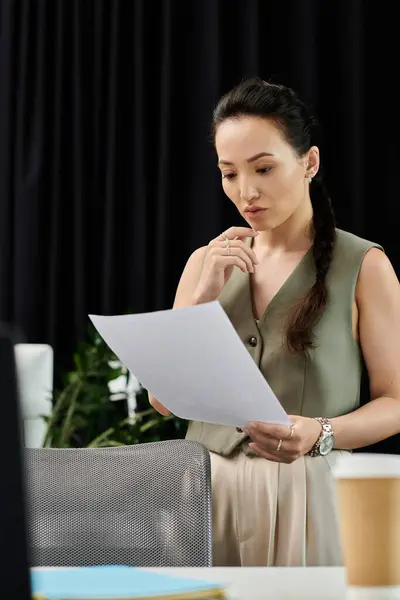 A poised businesswoman thoughtfully examines important documents in her stylish office. — Stock Photo