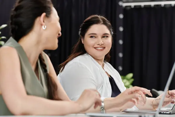 In a modern office setting, two stylish businesswomen share ideas and collaborate on projects. — Stock Photo