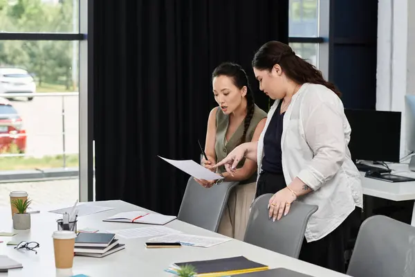 Two businesswomen thoughtfully discuss a project in their stylish office space. — Stock Photo