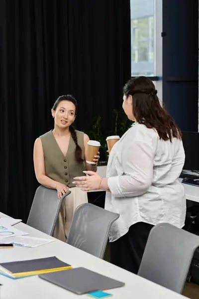 Two professional women share ideas and insights while enjoying coffee in a stylish office. — Stock Photo