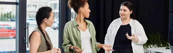 Three professional women engage in a lively conversation, sharing ideas in a stylish workspace. — Stock Photo