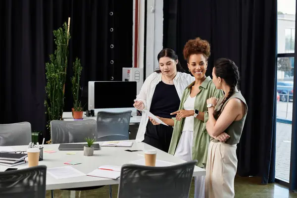 Three stylish business professionals engage in a lively discussion, sharing ideas and strategies. — Stock Photo