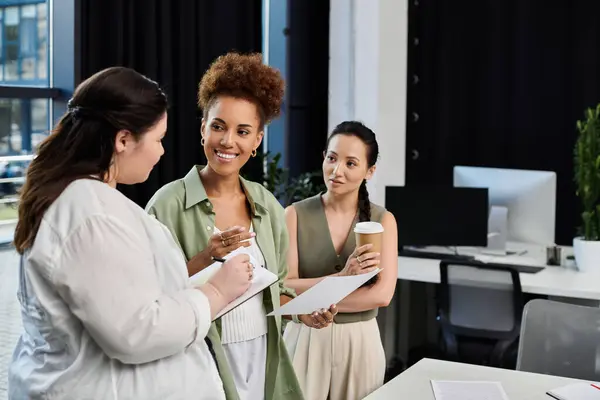 Three elegant businesswomen engage in a productive discussion at their stylish office workspace. — Stock Photo