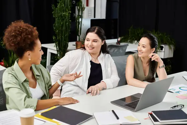 Three professional women collaborate and share ideas at a stylish office desk, enhancing teamwork. — Stock Photo