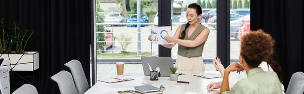 A confident woman shares important business analytics with her colleagues at an office meeting. — Stock Photo