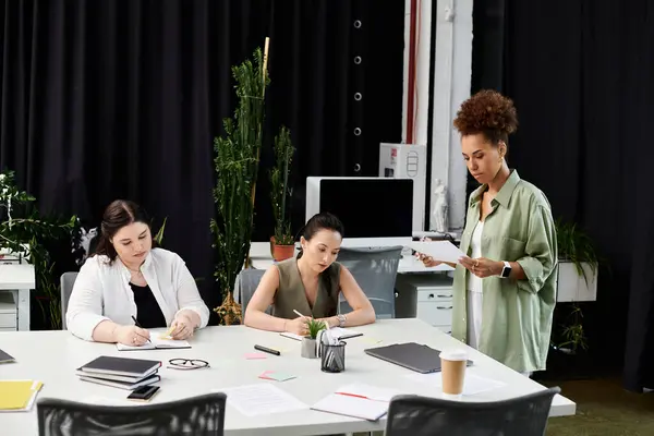 Three professionals engage in dynamic discussions and brainstorming in a stylish office environment. — Stock Photo