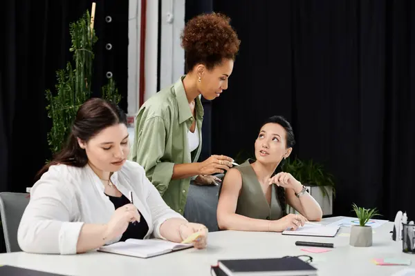 Three elegant businesswomen engage in lively discussion while working on a project together. — Stock Photo