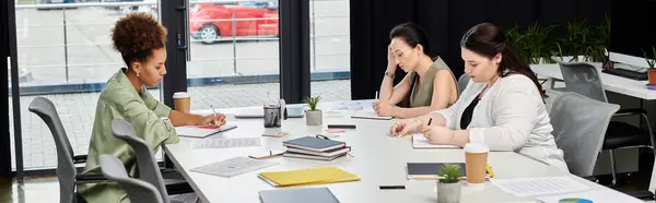 Drei stylische Profis konzentrieren sich auf ihre Aufgaben in einem hellen, modernen Büroumfeld. — Stockfoto