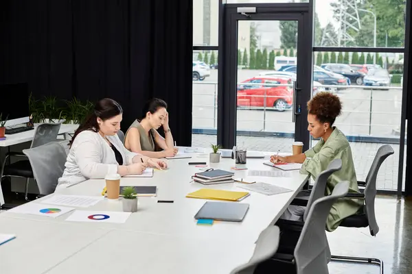 Three focused businesswomen engage in thoughtful discussions while working in a modern office. — Stock Photo