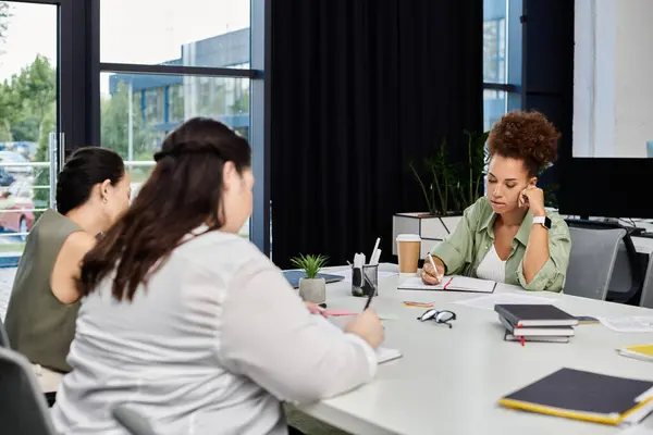 Three professional women brainstorm ideas and take notes in a contemporary office environment. — Stock Photo