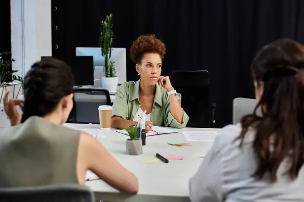 Three business professionals strategize in a modern office setting, focused on key decisions. — Stock Photo