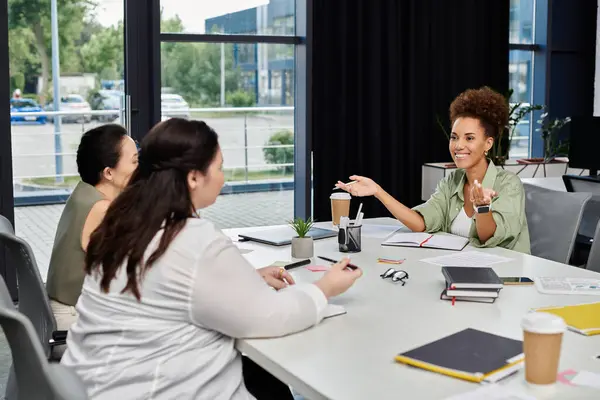 Three professional women collaborate enthusiastically in a bright office space. — Stock Photo