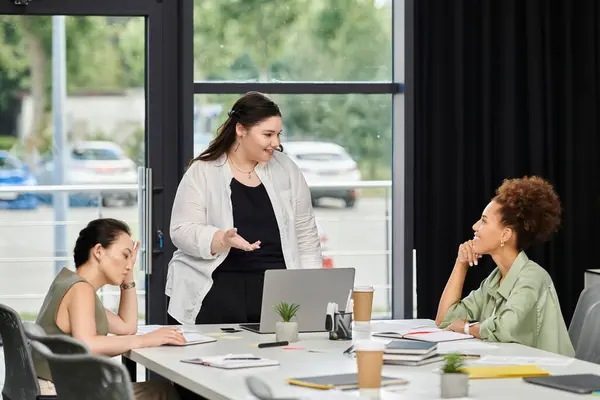 Three stylish businesswomen collaborate and share ideas in an office. — Stock Photo