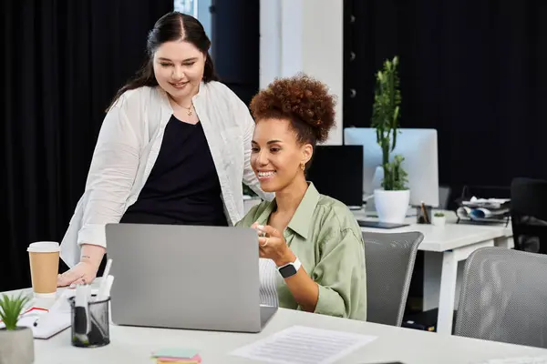 Due donne professionali si impegnano in una discussione collaborativa mentre lavorano su un computer portatile. — Foto stock