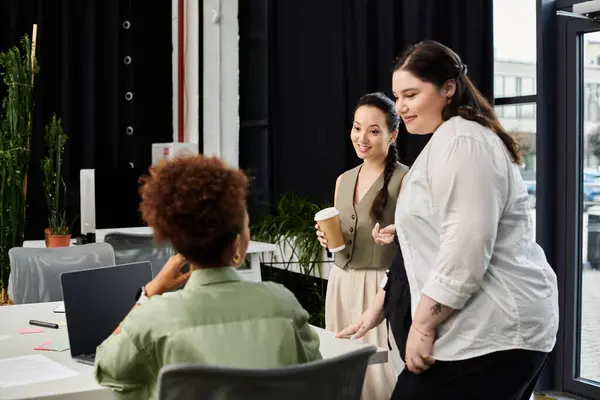 Three businesswomen engage in a dynamic conversation in a stylish office space. — Stock Photo