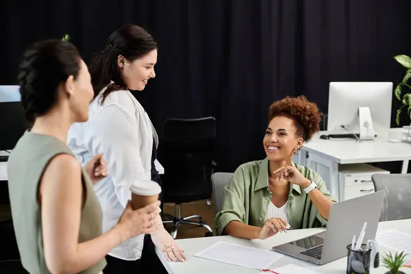 Three professionals engage in a lively discussion while working in a contemporary office setting. — Stock Photo