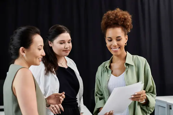 Trois femmes professionnelles participent à une discussion collaborative tout en examinant des documents importants. — Photo de stock