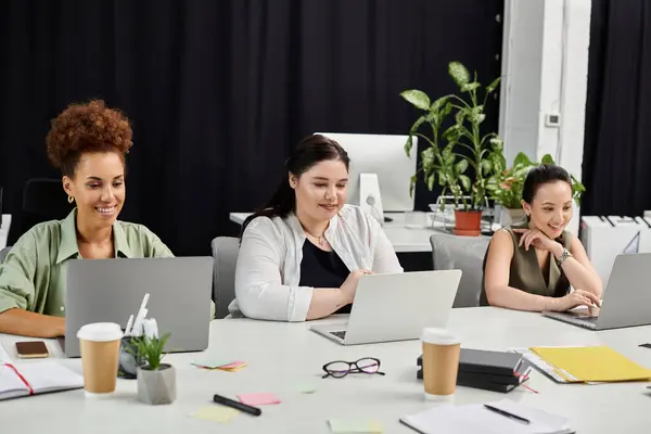 Dynamic atmosphere as three professional women engage in productive teamwork at their desks. — Stock Photo