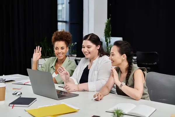 Tre donne professionali condividono idee e risate mentre confermano in uno spazio ufficio dinamico. — Foto stock