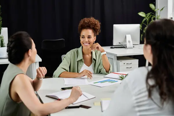 Three business professionals engage in a lively discussion, sharing ideas in an office. — Stock Photo
