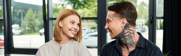 Two young coworkers share a light moment while brainstorming in a vibrant workspace. — Stock Photo