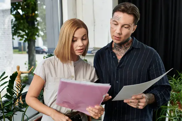 Two coworkers engage in a focused discussion over important documents amidst greenery. — Stock Photo