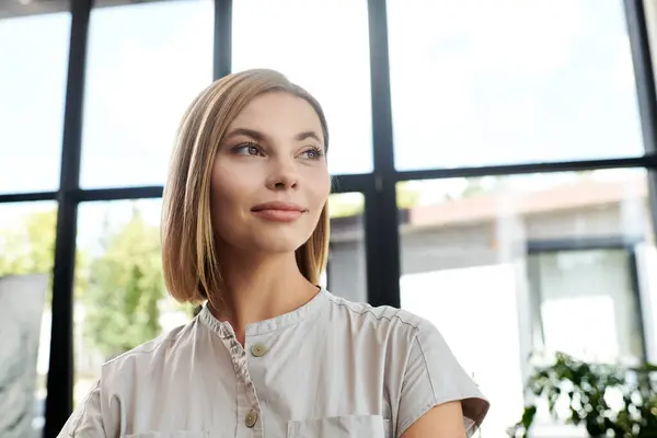 A young woman at her desk enjoys a moment of contemplation in a sunny workplace. — Stock Photo