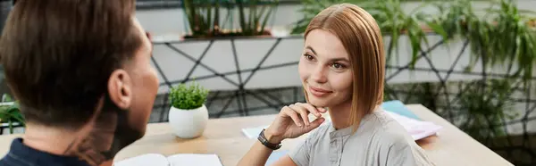 Молода пара обговорює ідеї за яскравим, заповненим рослинами офісним столом. — стокове фото