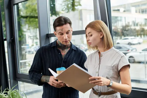 Two young coworkers collaborate on a project while enjoying their time in the office. — Stock Photo