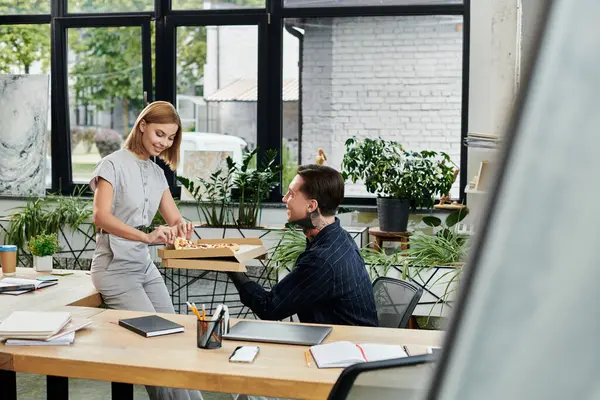 Two colleagues enjoy a casual lunch together in a bright office filled with plants. — Stock Photo