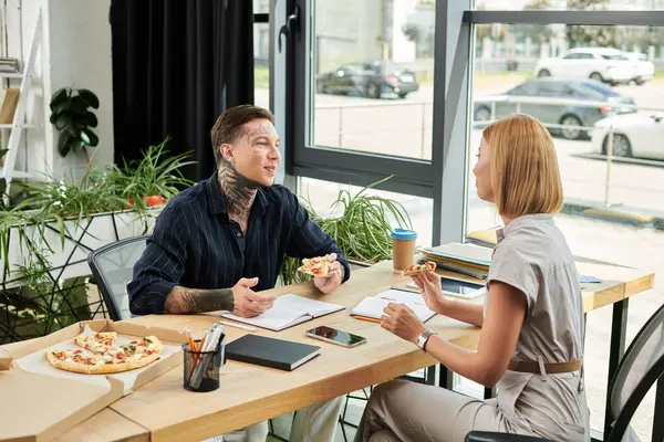 Zwei Kollegen teilen sich eine Pizza und unterhalten sich in der Mittagspause freundlich. — Stock Photo