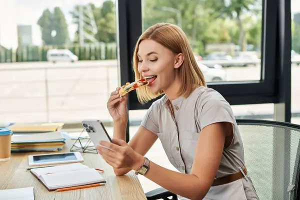 Young professional savoring pizza during a busy workday. — Stock Photo