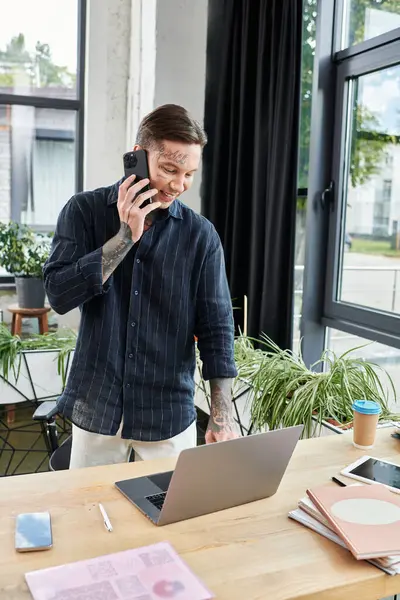 Un giovane collega condivide le idee al telefono mentre lavora diligentemente alla scrivania. — Foto stock