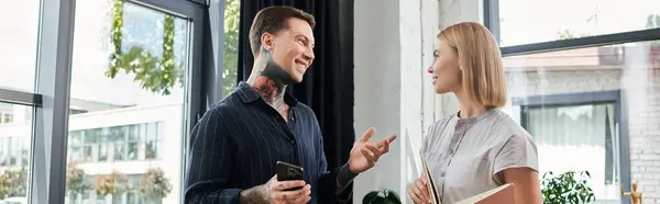 Two coworkers collaborate energetically, sharing ideas in a bright office environment. — Stock Photo
